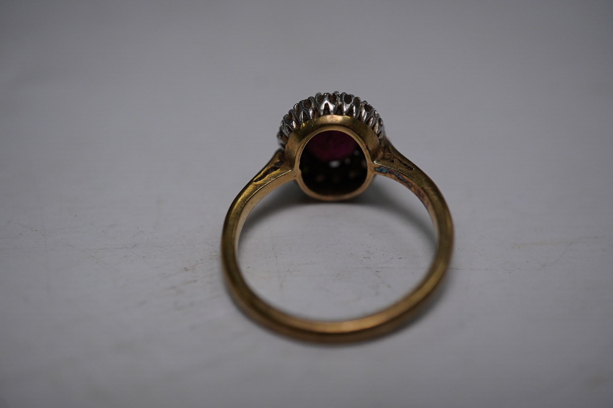 A 9ct and plat, garnet and diamond chip set oval cluster ring, size L, gross weight 3.9 grams. Condition - fair